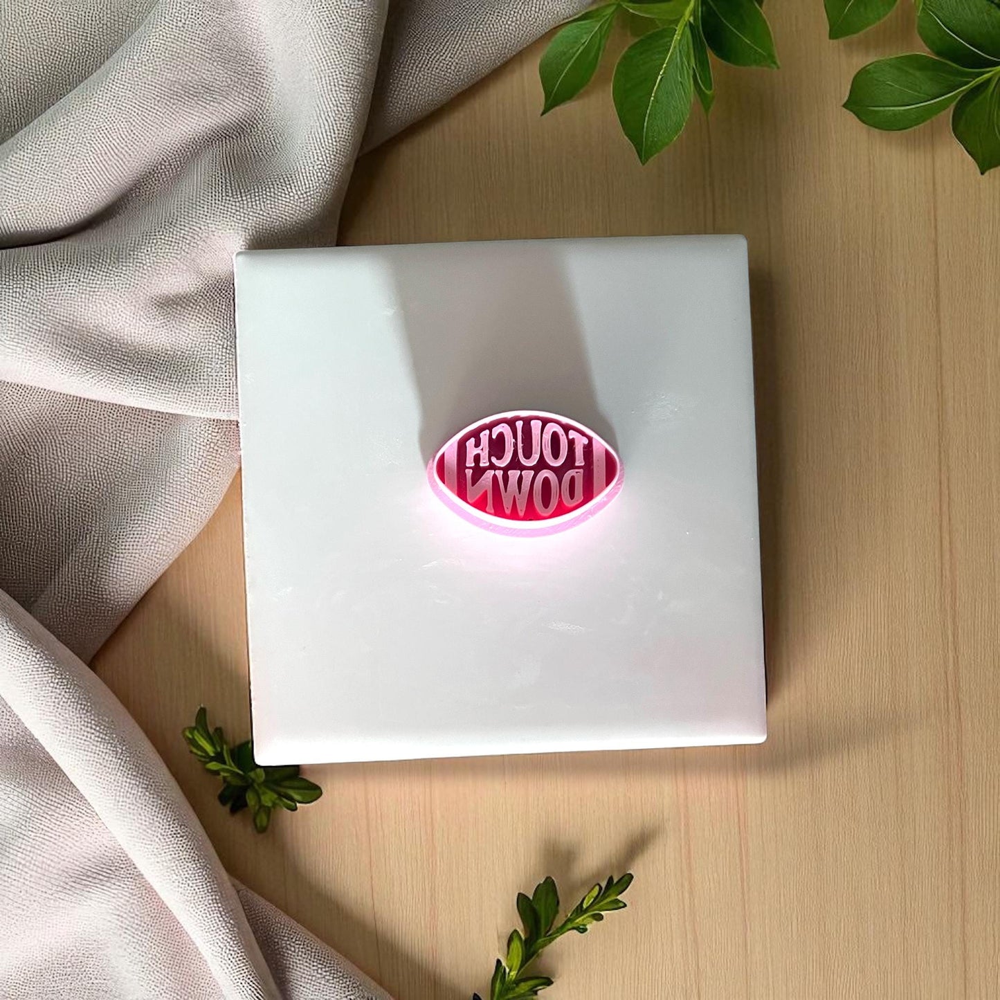 Large football touchdown clay imprint on wooden plate