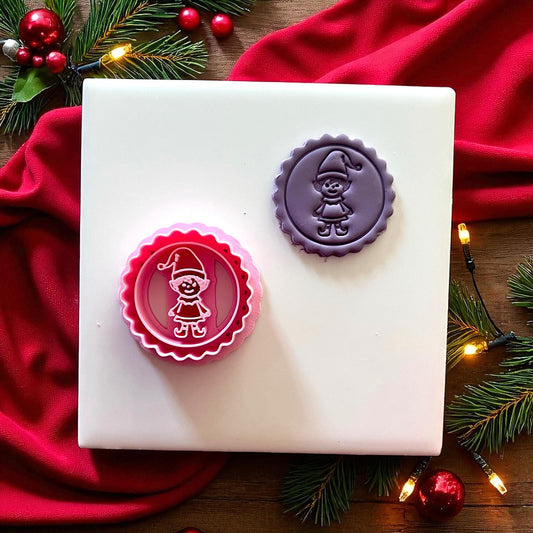 Purple elf clay imprint on plate with Christmas lights and ornaments.