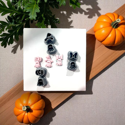 Three small pink ghost clay shapes with bow, witch hat, and boo