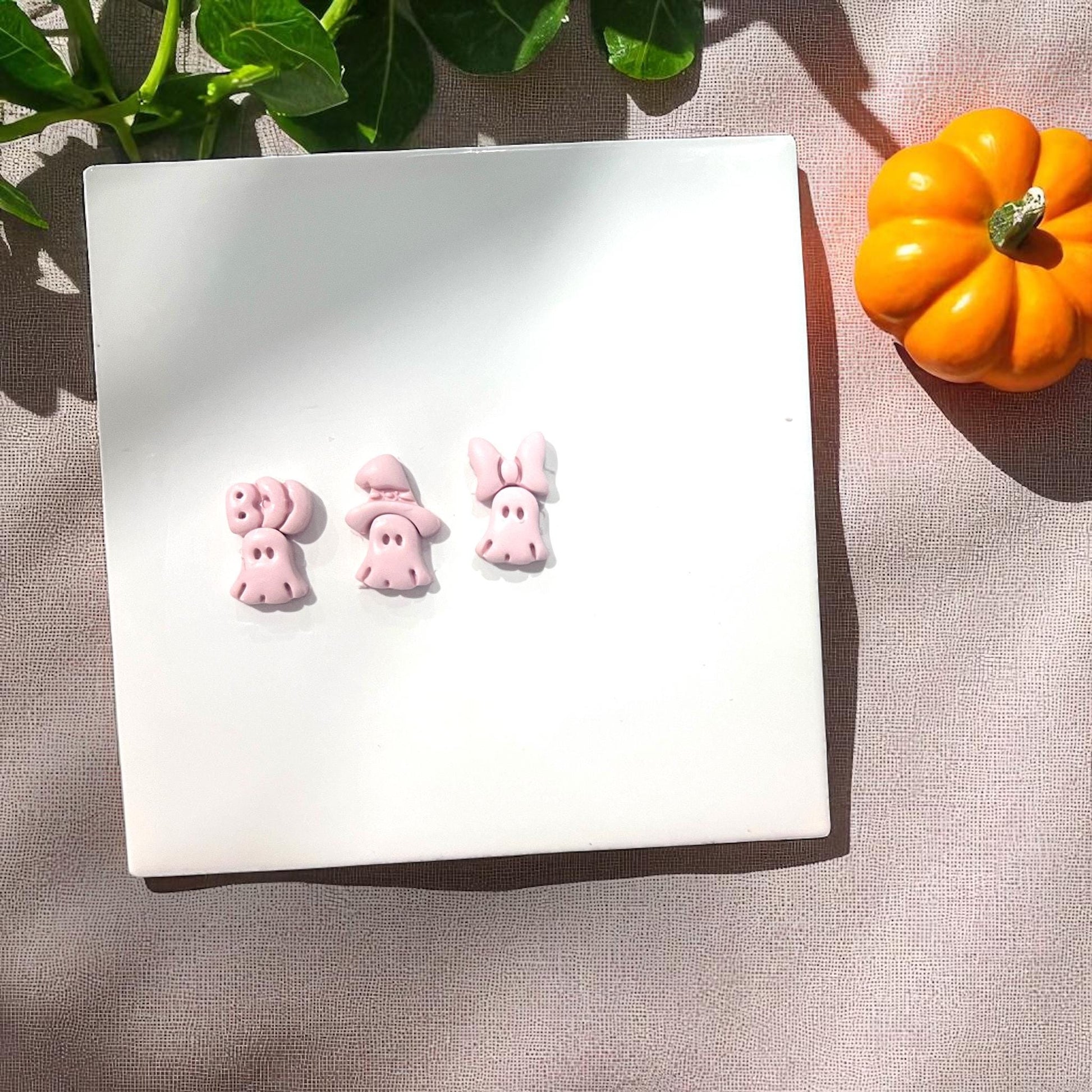 Pink clay slab with ghost impressions of bow, witch hat, and boo