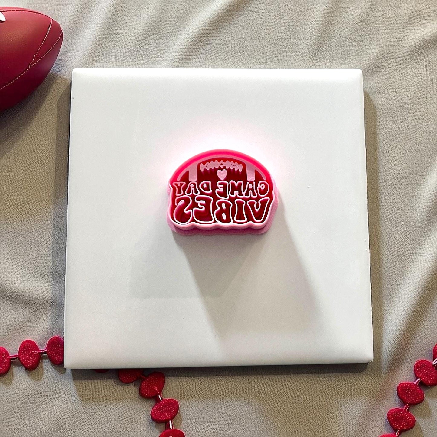 Pink football game day vibes cutter on white tile