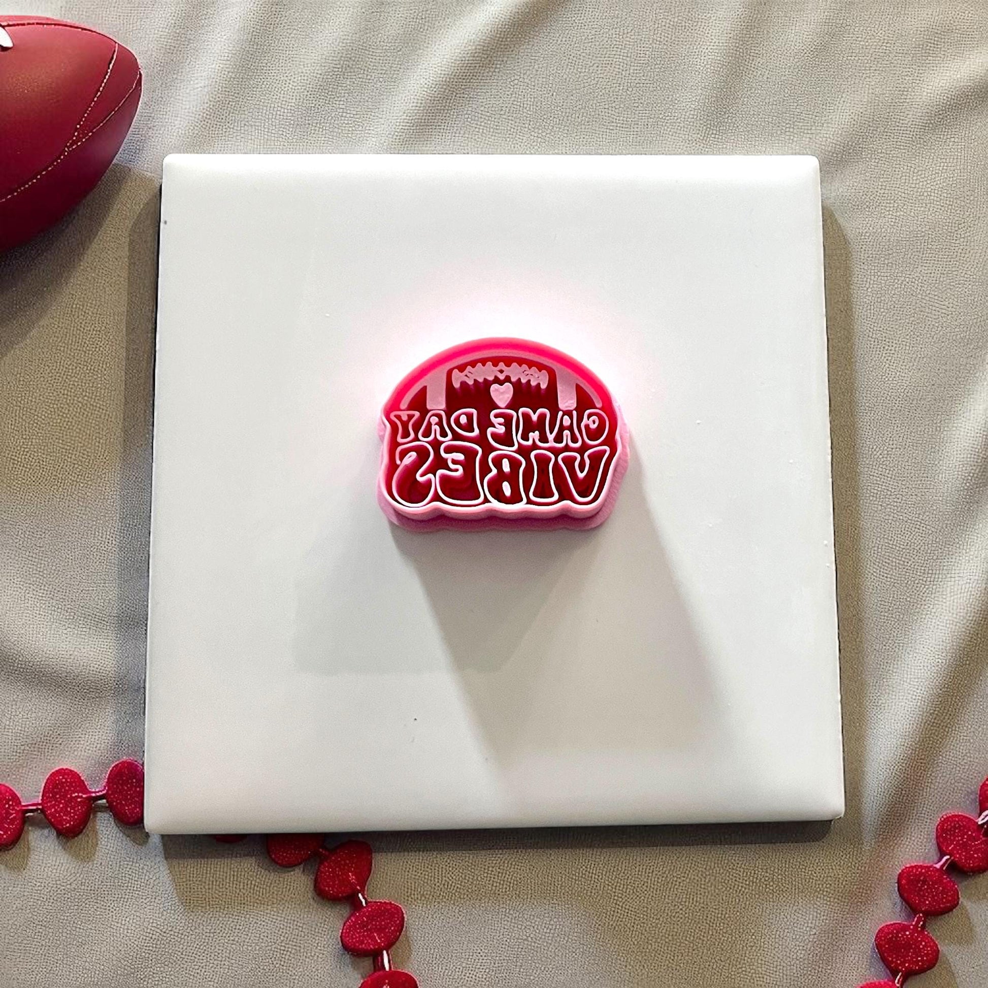 Pink football game day vibes cutter on white tile