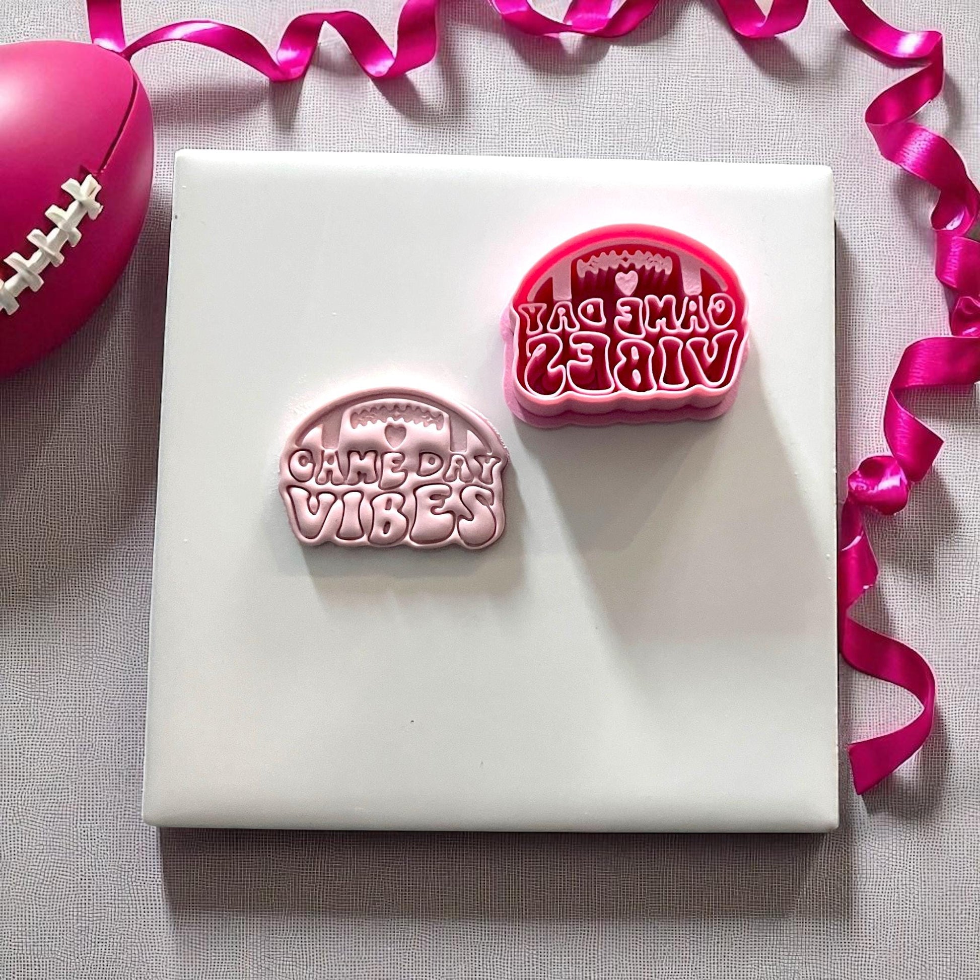 Pink cutter and clay imprint reading game day vibes with football