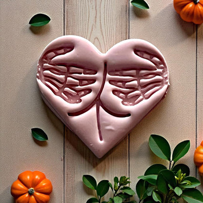 Large pink skeleton hands heart clay piece with pumpkins and leaves