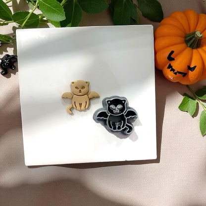 Vampire kitten clay piece and cutter side by side with pumpkin