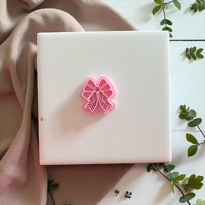 Polymer clay cutter and football bow imprint side by side