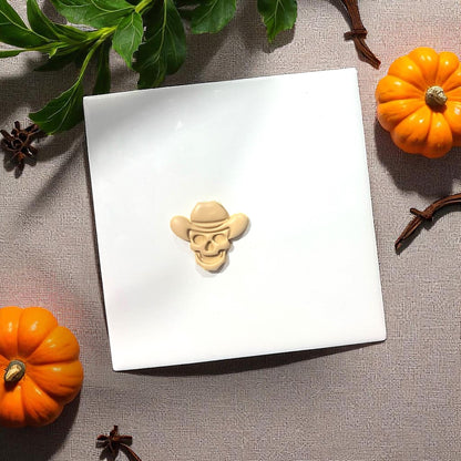 Cowboy skull clay shape on white tile with pumpkins