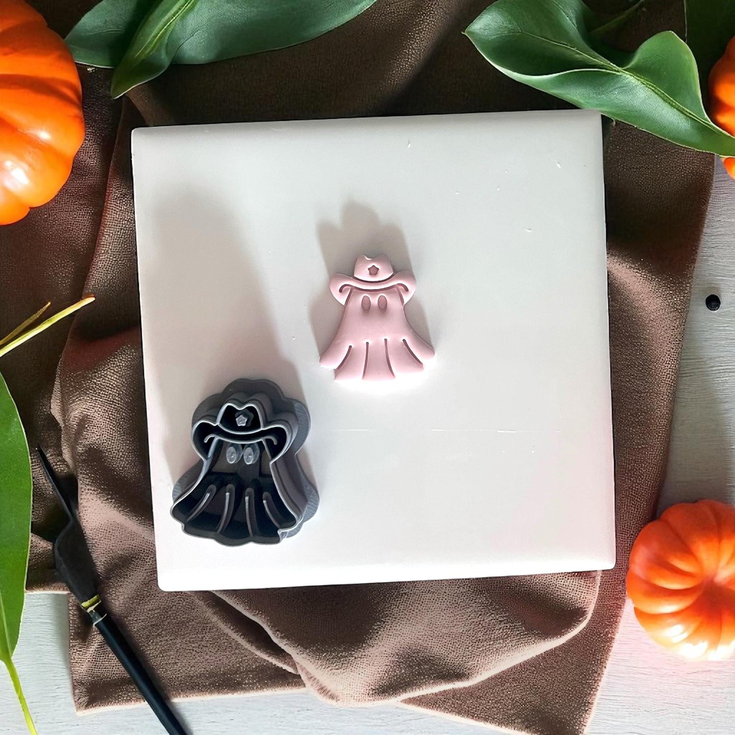 Cowboy ghost cutter and clay piece on tile with pumpkins