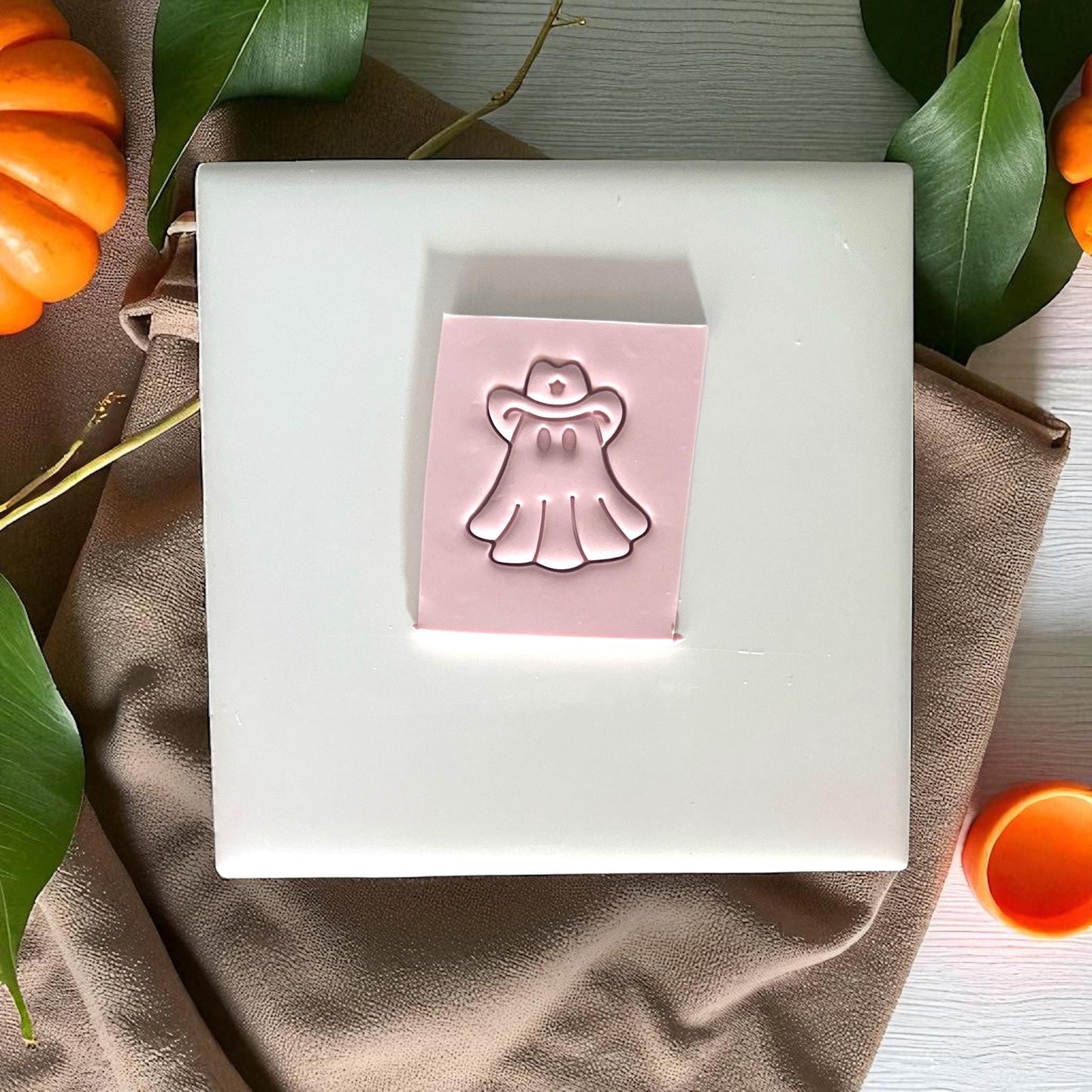 Cowboy ghost clay imprint on slab with pumpkins