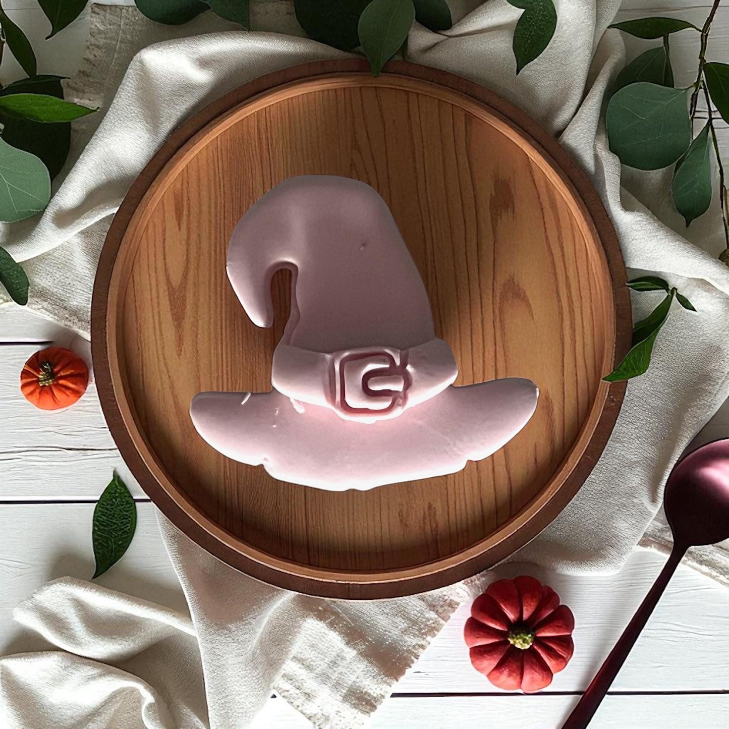 Witch hat clay cutter and buckle cutter on white tile with pumpkins