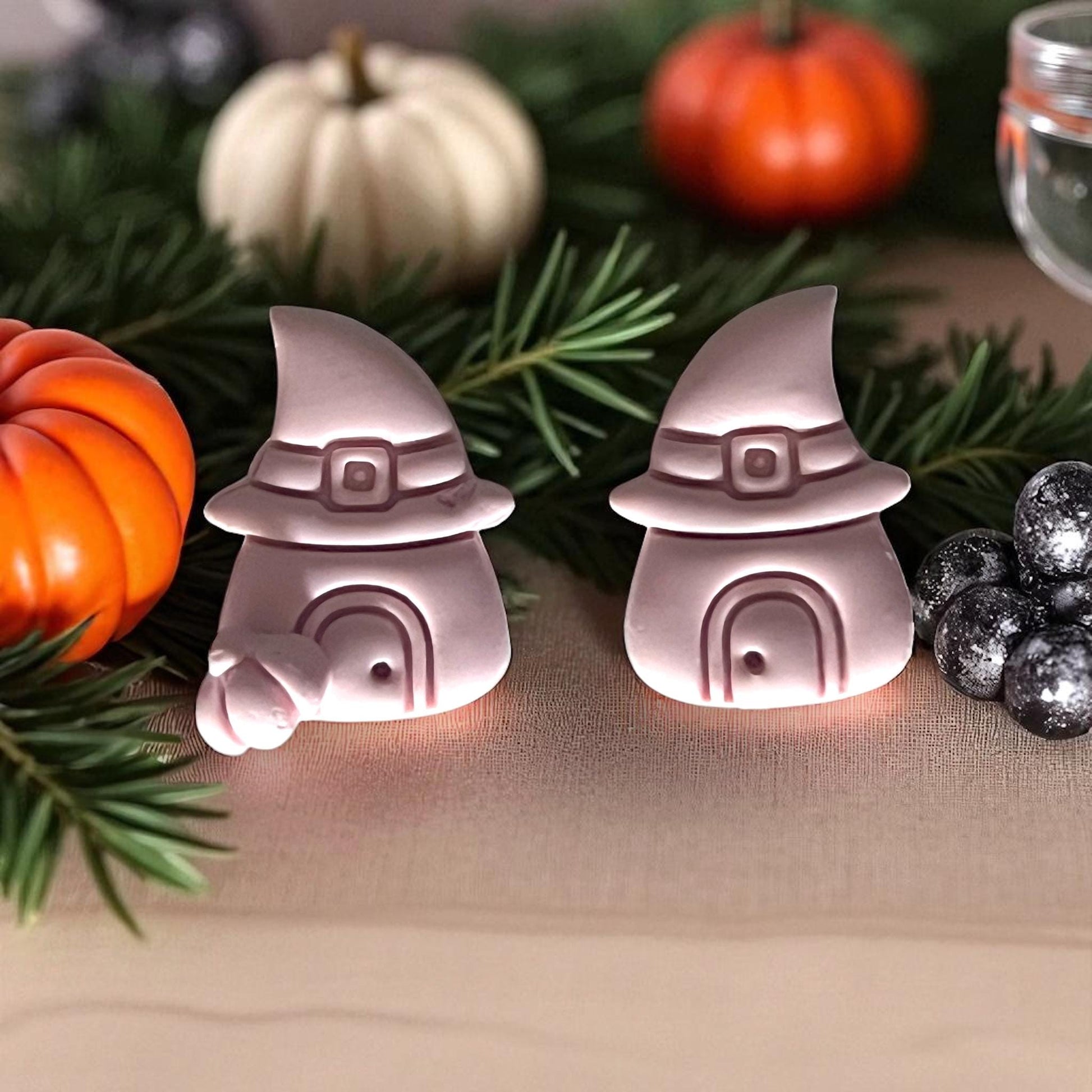 Pink witch hat houses made from clay with pumpkins and greenery