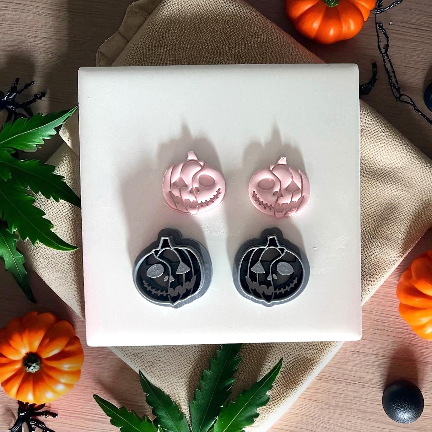 Pumpkin skull cutters with clay designs on white tile