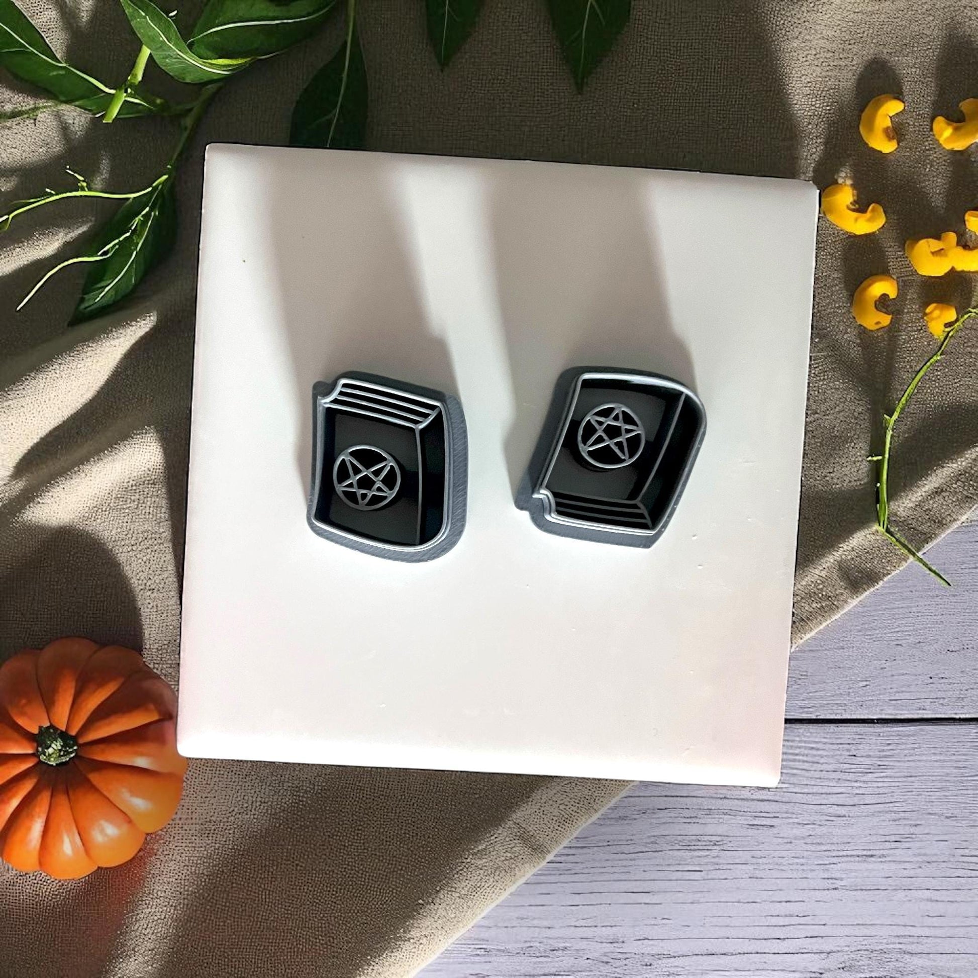 Spellbook clay cutters with pentagram design on white tile