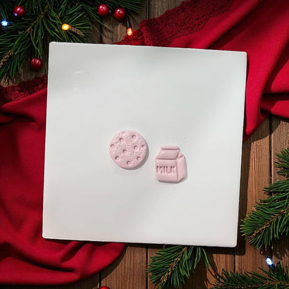 Small milk carton and cookie clay pieces on white background with red cloth