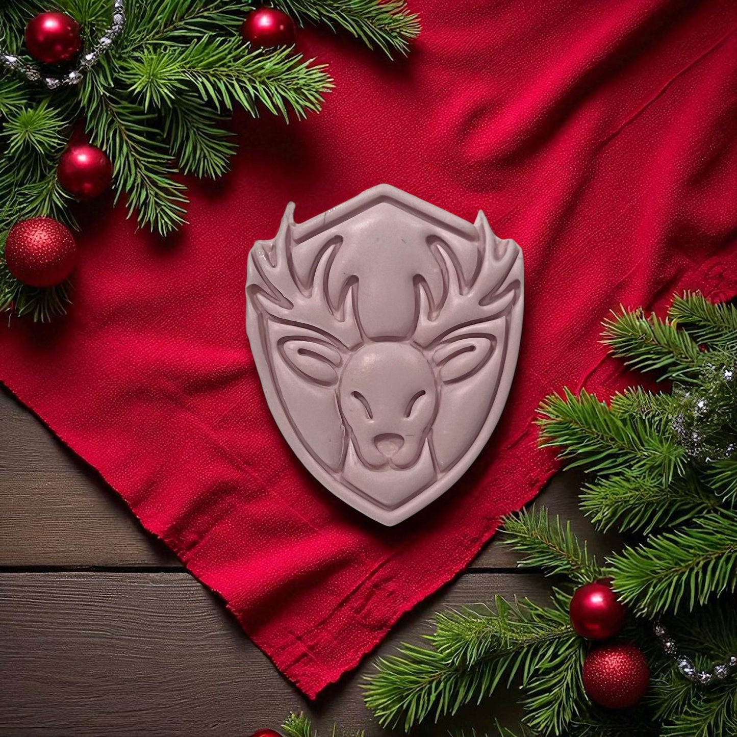 Reindeer clay imprint on red cloth with pine and ornaments