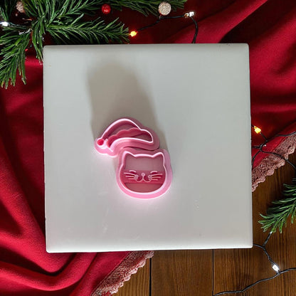 Santa cat clay cutter on white tile with red Christmas fabric