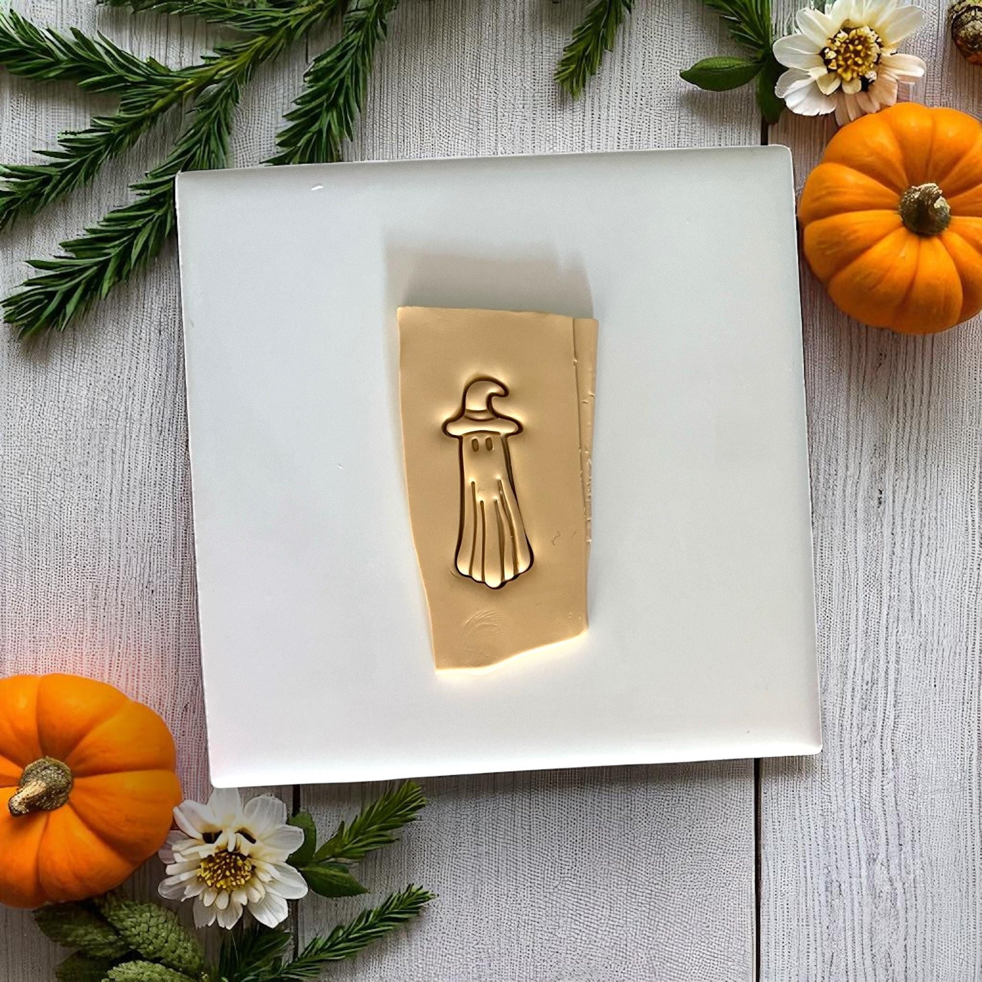 Ghost design pressed into golden clay sheet