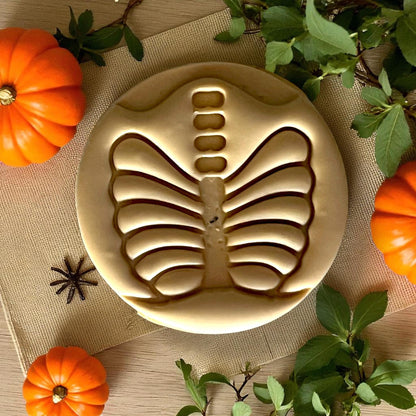 Close-up golden ribcage skeleton clay design with pumpkins
