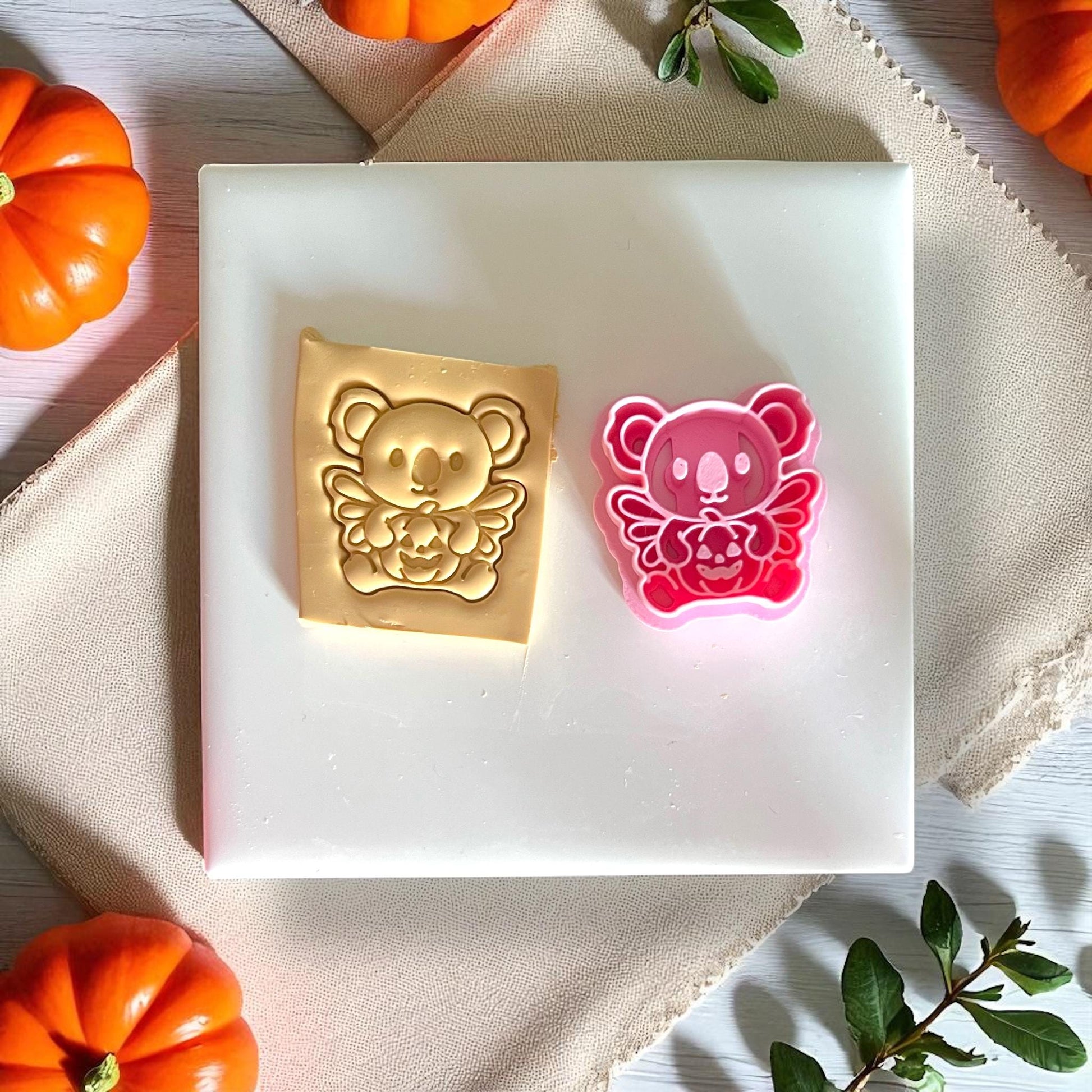Pink koala pumpkin clay cutter next to golden clay design