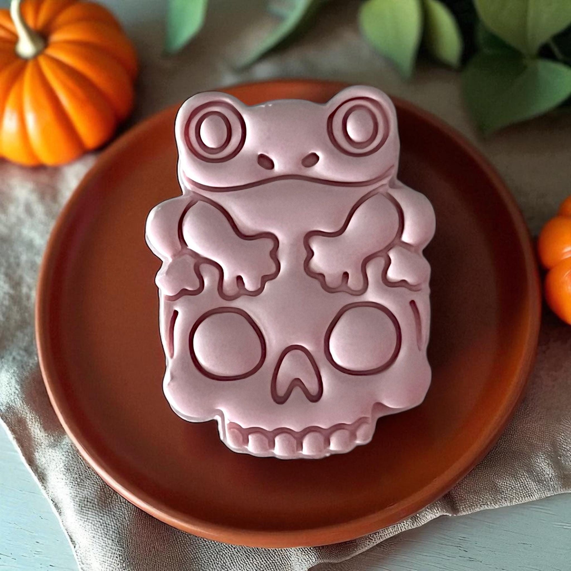 Close-up frog on skull clay design on orange plate
