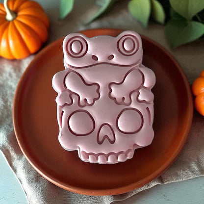 Close-up frog on skull clay design on orange plate