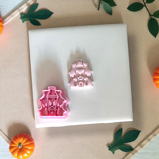Pink haunted house clay piece next to pink clay cutter