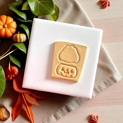 Pumpkin jack o lantern clay impressions with cutter outlines on beige fabric