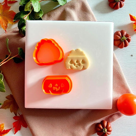 Pumpkin cutter set with jack o lantern face and clay imprint on white tile