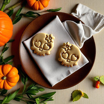 Large golden skull clay cutouts with heart eyes and flower on brown plate