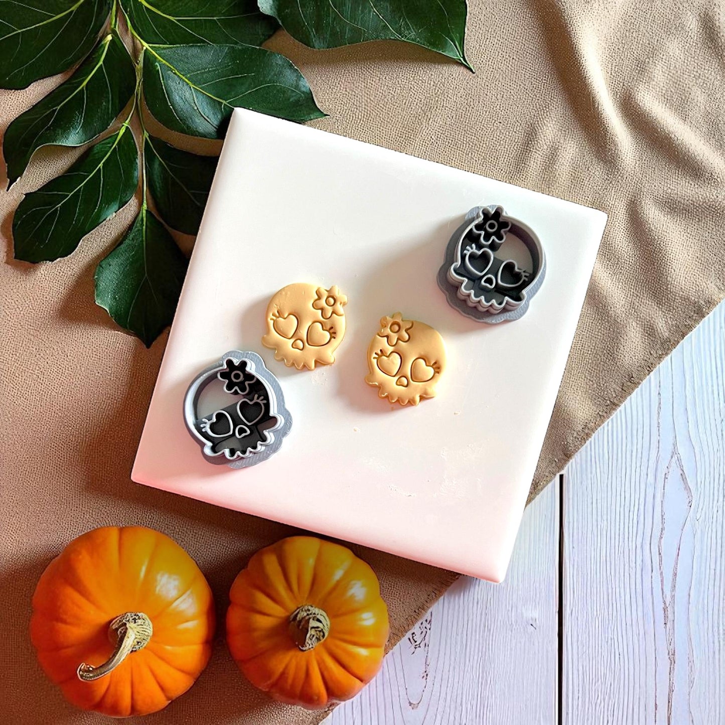 Skull clay cutters with heart eyes and flower alongside clay imprints