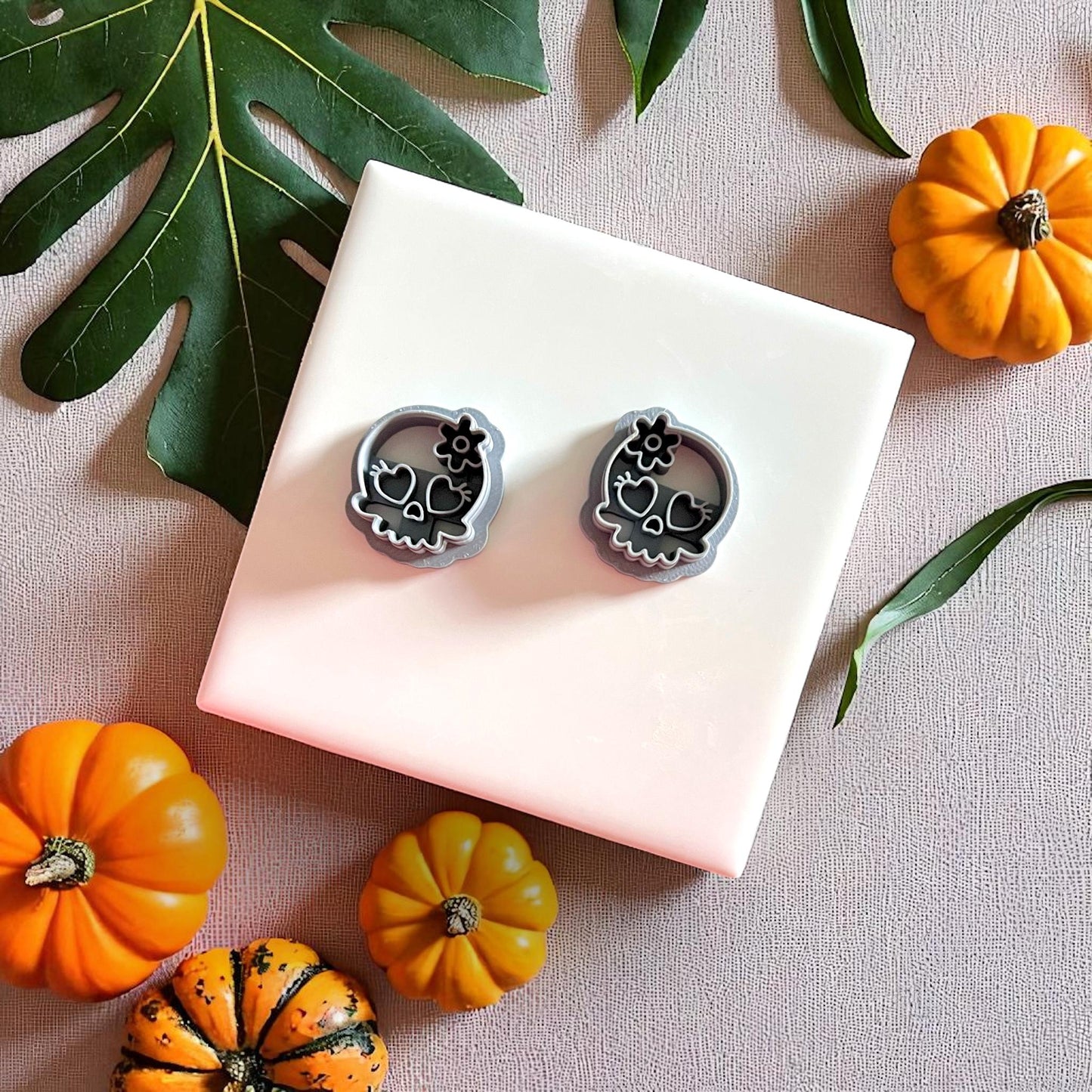 Skull clay cutters with heart eyes and flower alongside clay imprints