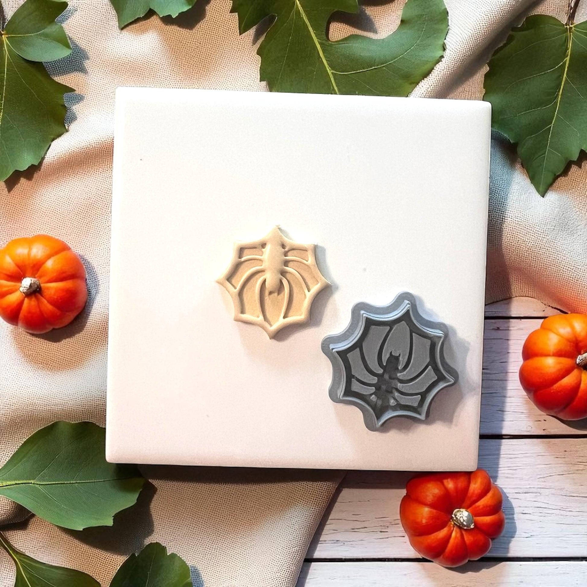 Spider web clay cutter with beige clay imprint on white tile