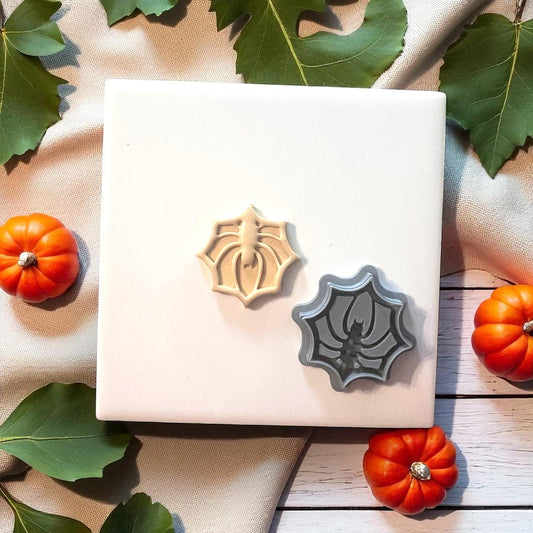 Spider web clay cutter with beige clay imprint on white tile