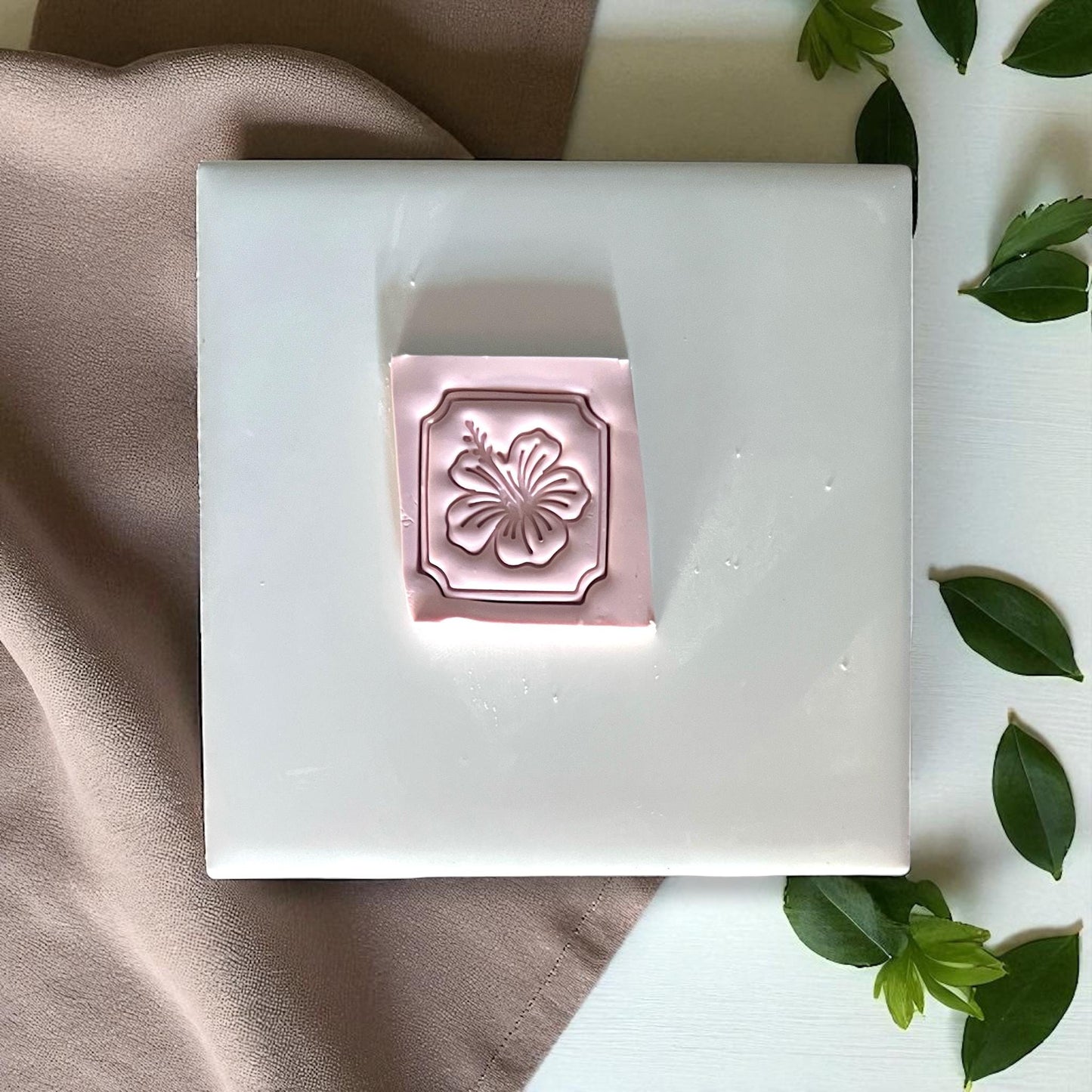 Pink hibiscus clay cutter with frame design on white tile