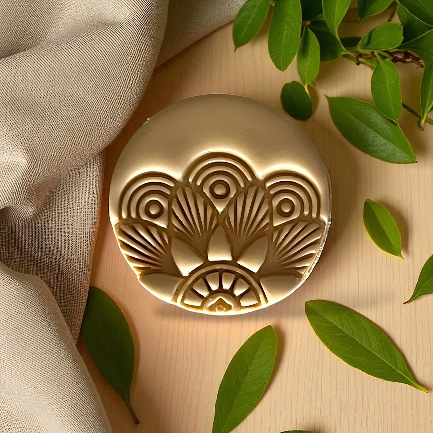 Round Art Deco clay design on white tile with fabric