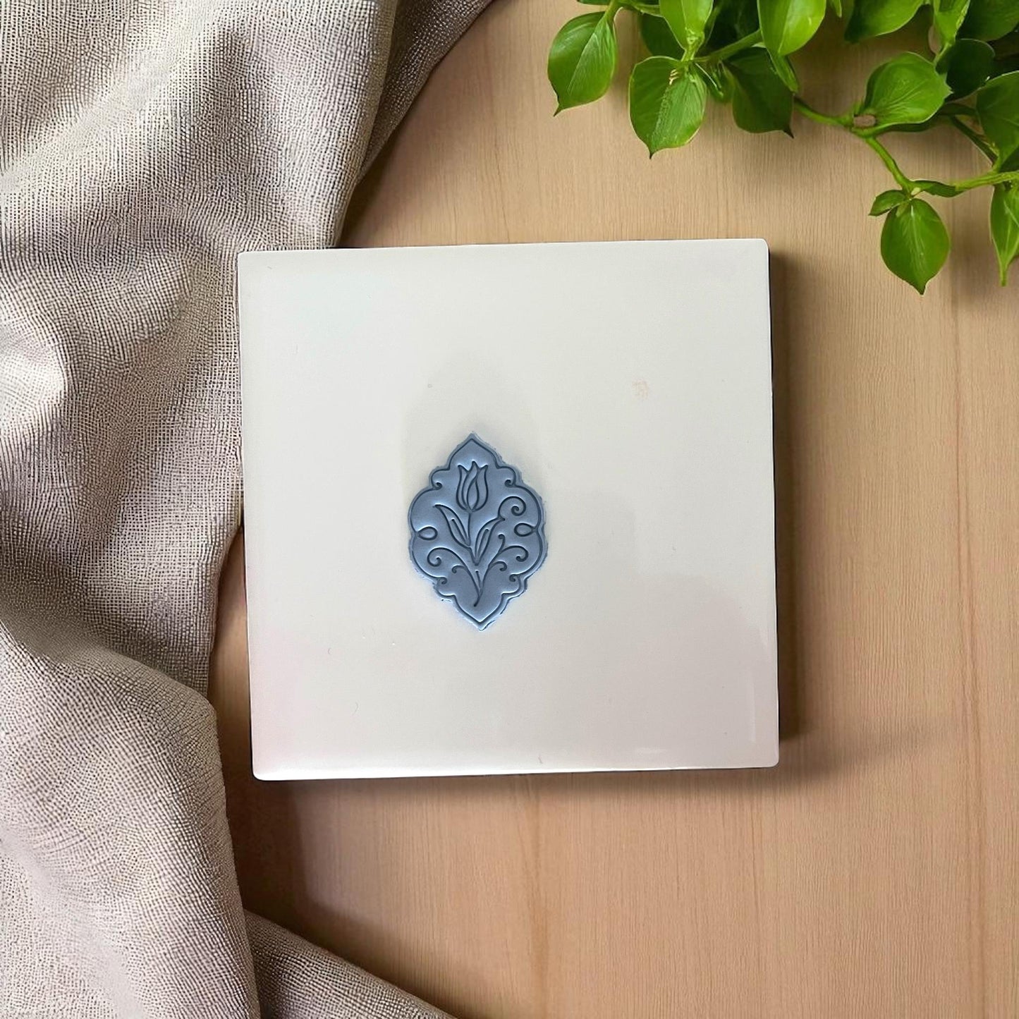 Small gray tulip floral clay design on square white tile