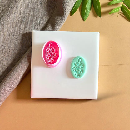 Pink snake clay cutter with teal clay snake design