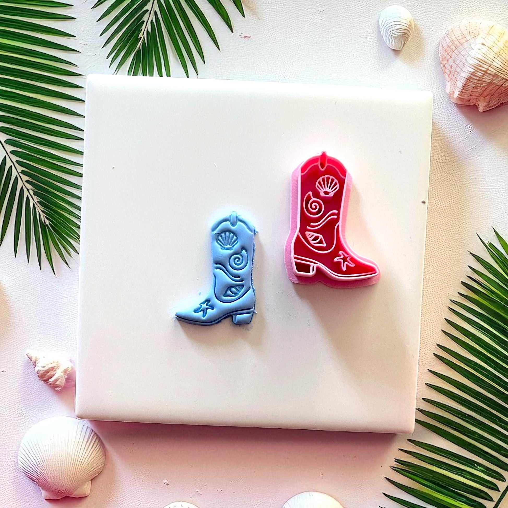 Red cutter and blue cowboy boot clay piece side by side