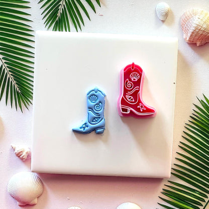 Red cutter and blue cowboy boot clay piece side by side