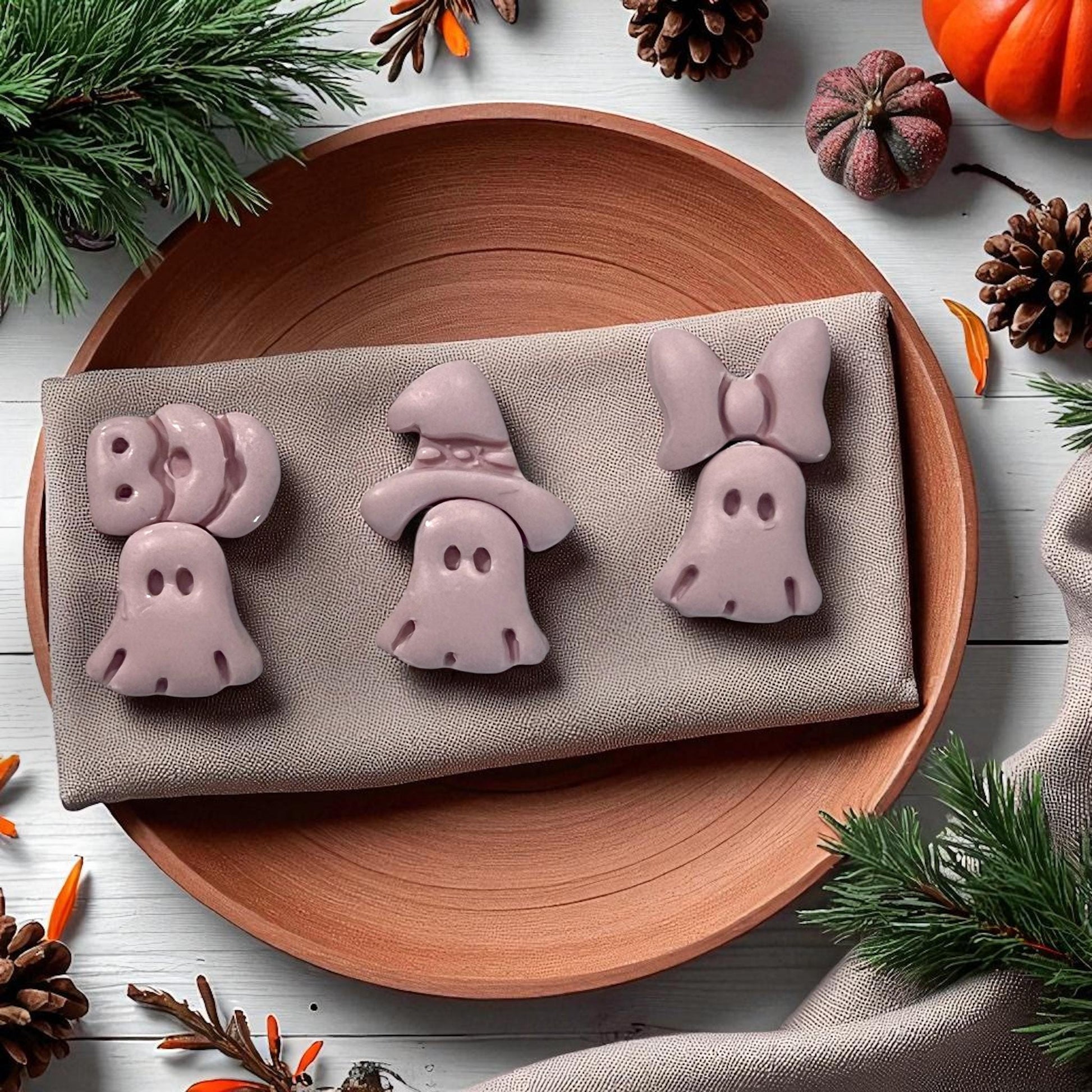 Finished ghost clay shapes with bow, witch hat, and boo on plate