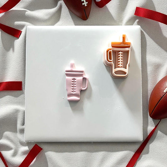 Pink clay football Stanley tumbler with cutter on white background