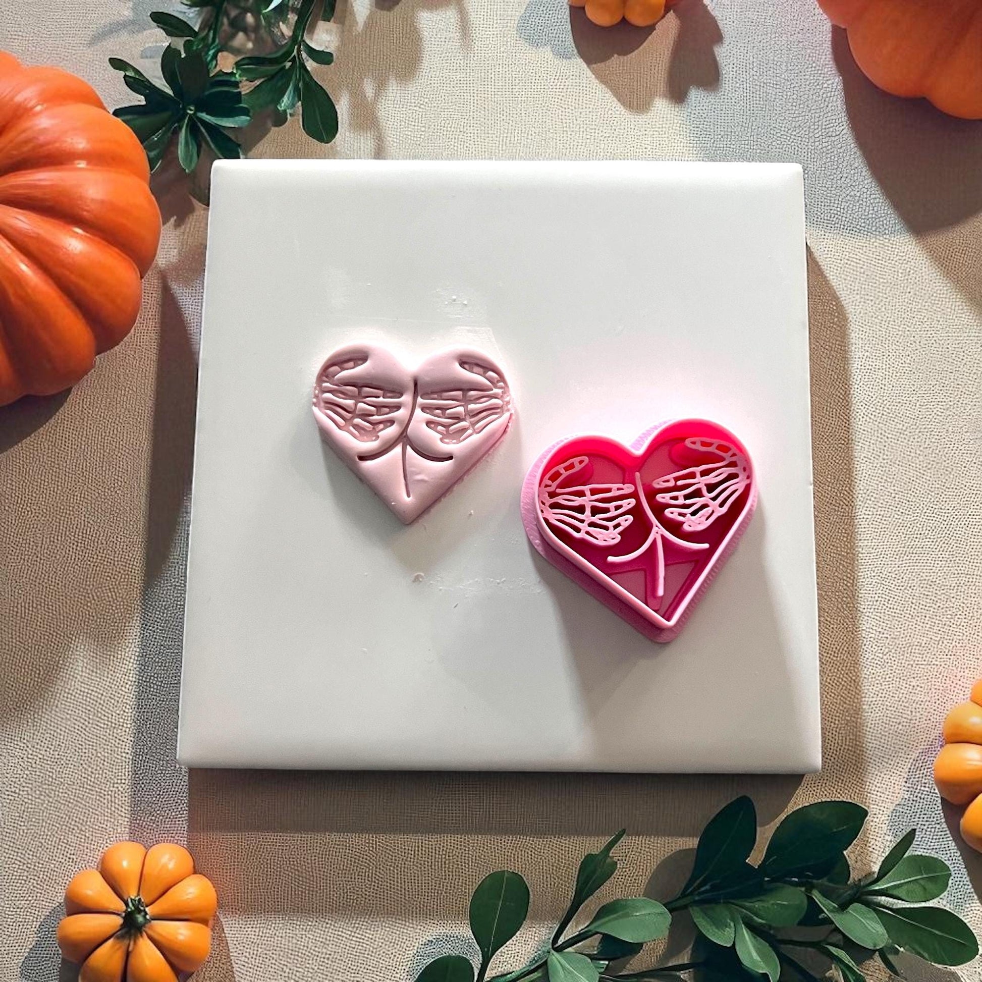 Pink cutter and pink clay skeleton hands heart design together