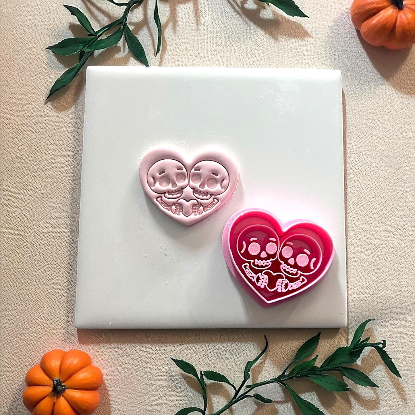Pink skeleton couple heart clay piece with cutter beside it