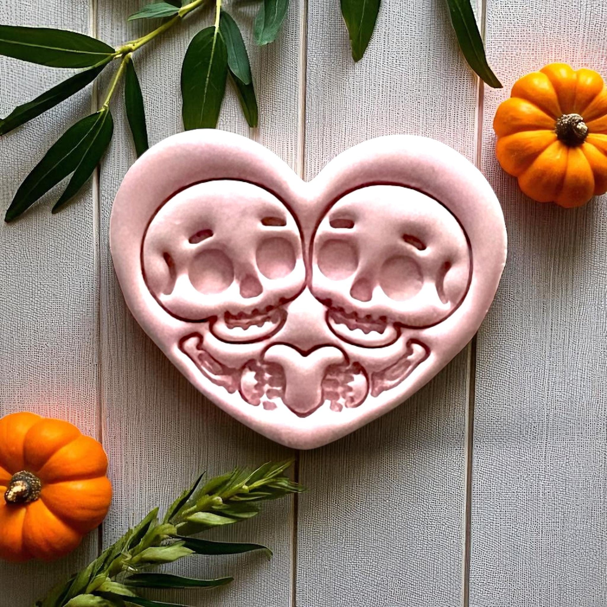 Large pink skeleton couple heart clay piece with pumpkins and leaves