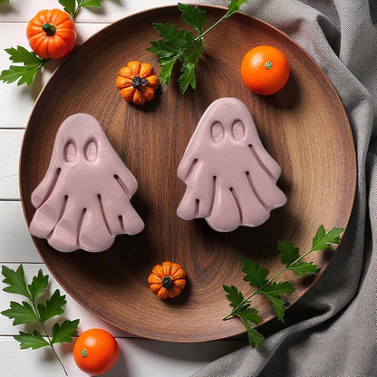 Large purple clay ghosts on wooden plate with pumpkins and leaves