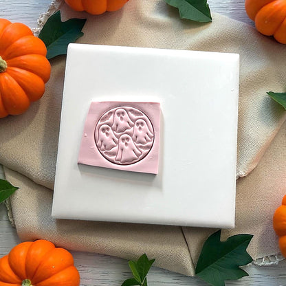 Pink clay ghost circle impression on white tile with pumpkins