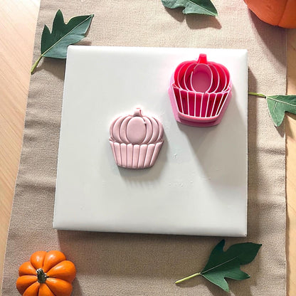 Pink pumpkin cupcake clay impression on white tile with pumpkins