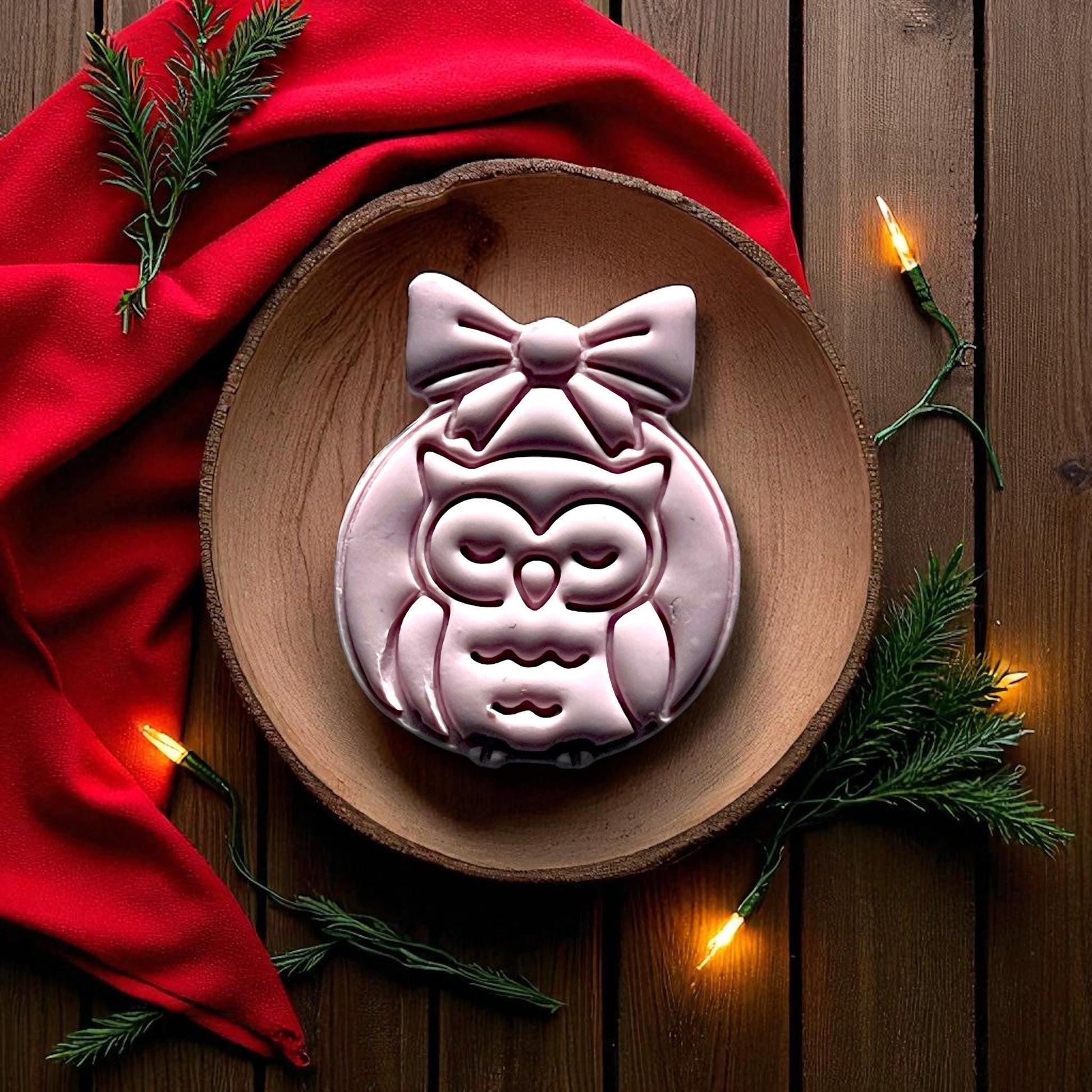 Close-up of owl ornament clay imprint with pinecone and greenery