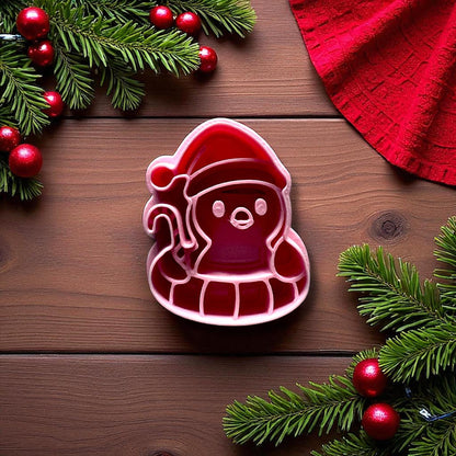 Close-up penguin floatie polymer clay cutter with Santa hat and candy cane