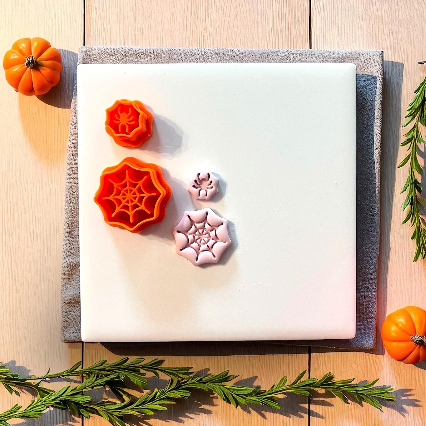 Spiderweb and spider clay cutters with clay impressions on white tile